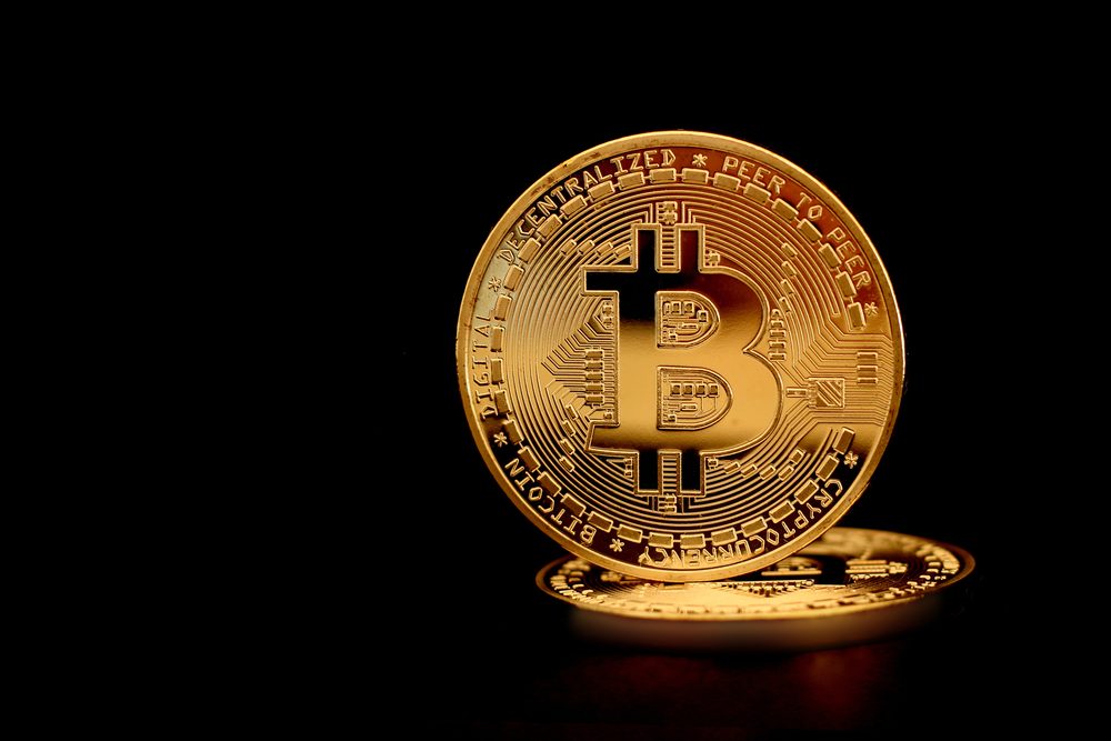 Bitcoin coin half-buried in soil
