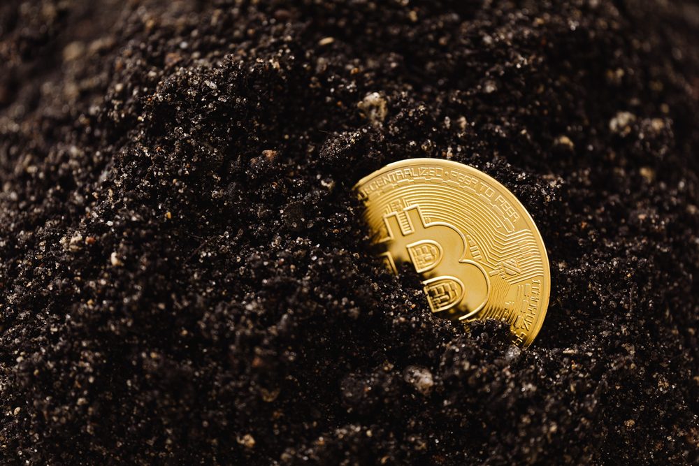 Bitcoin coin standing on a dark surface